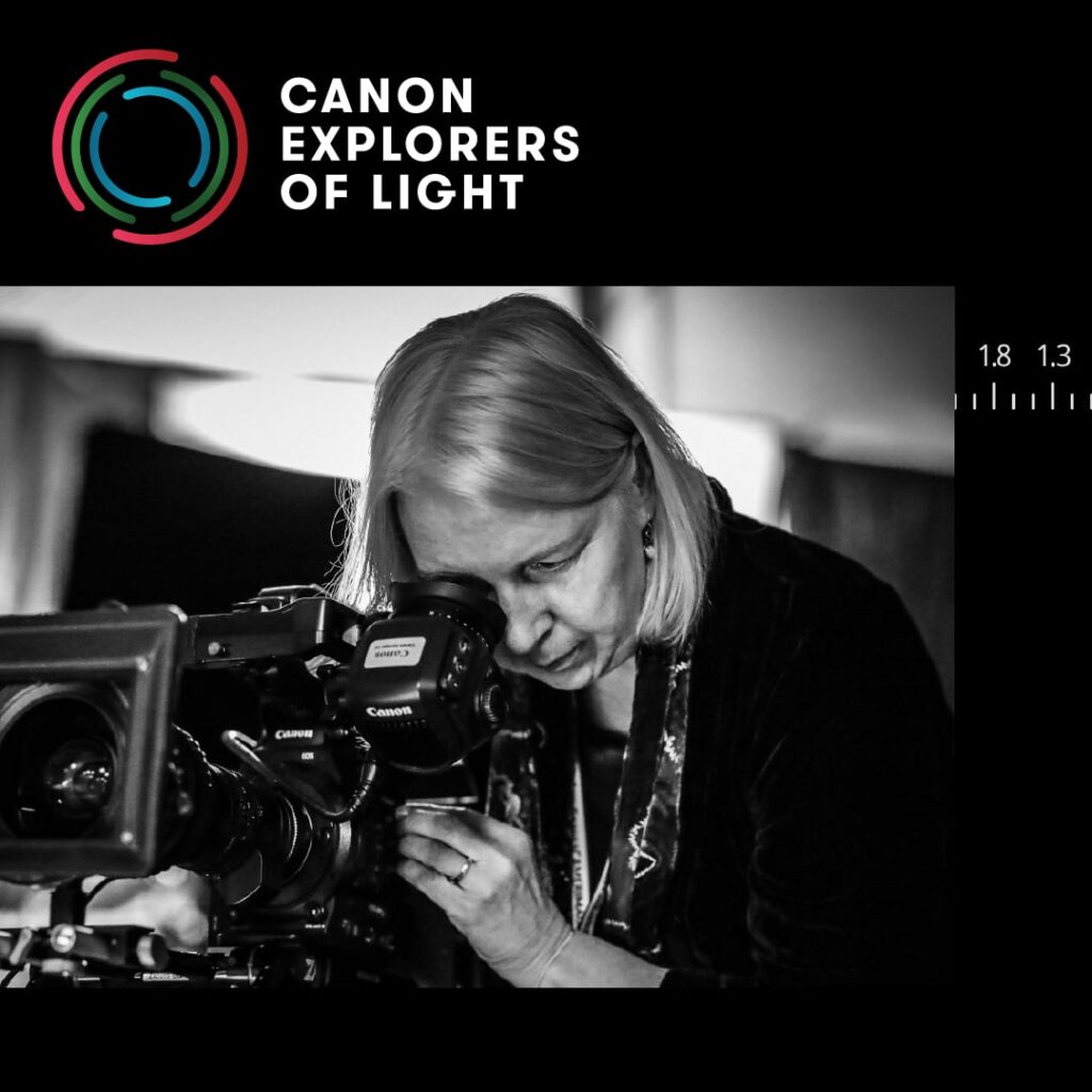 Photo of Canon Explorer of Light Artist, DP Claudia Raschke looking through the viewfinder on a big camera rig